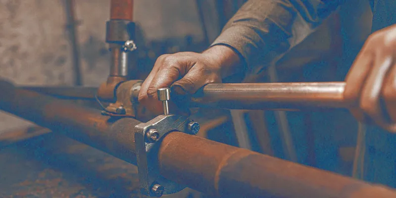 A pipe cutter slicing through black iron pipe